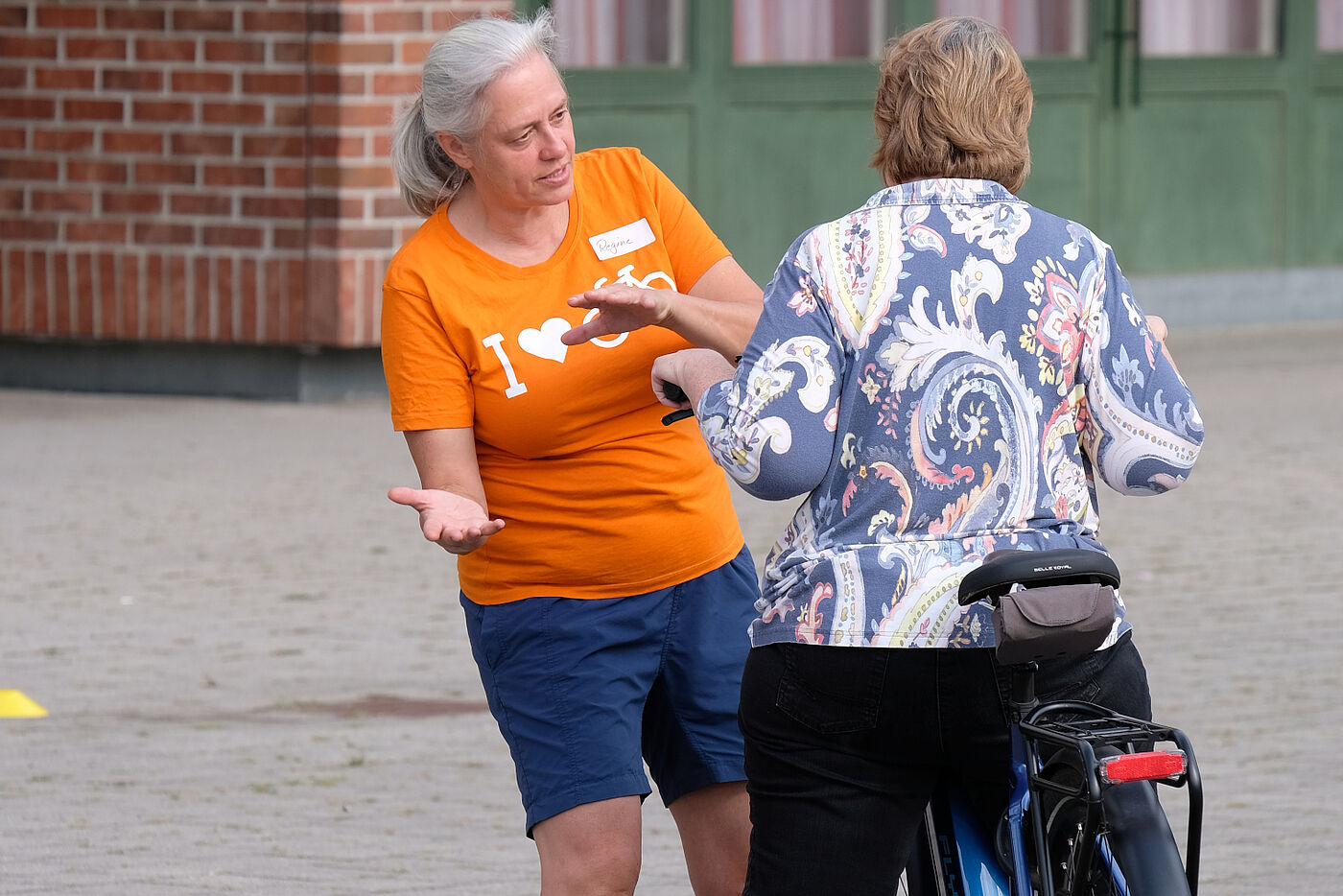 Fahrlehrerin erklärt Radfahrerin Umgang mit Rad