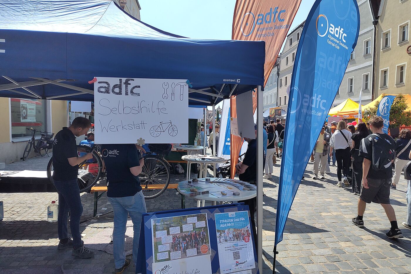 Blauer ADFC Pavillon mit Schild mit der Aufschrift Selbsthilfewerkstatt