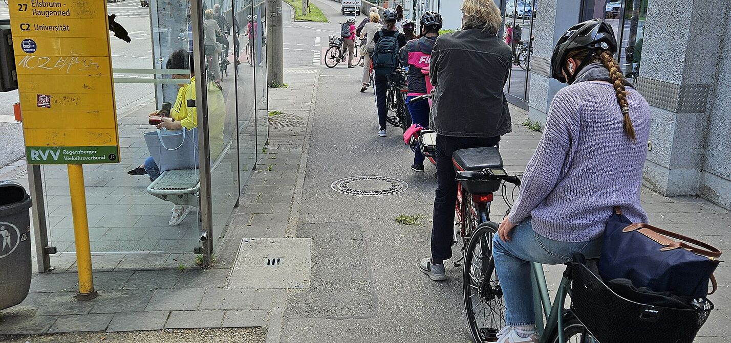 Stau aus Fahrradfahrenden, die an roter Ampel warten