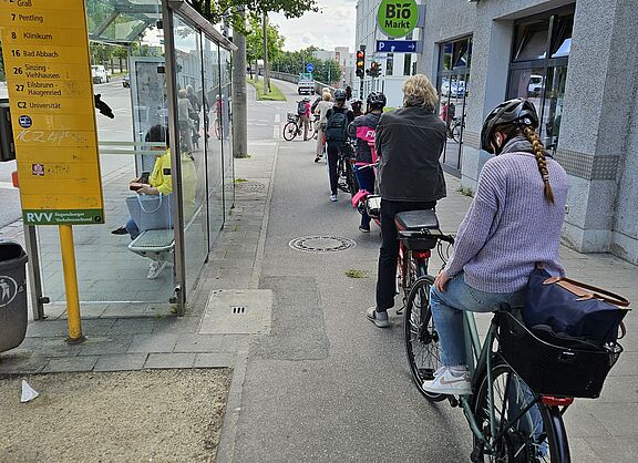 Stau aus Fahrradfahrenden, die an roter Ampel warten